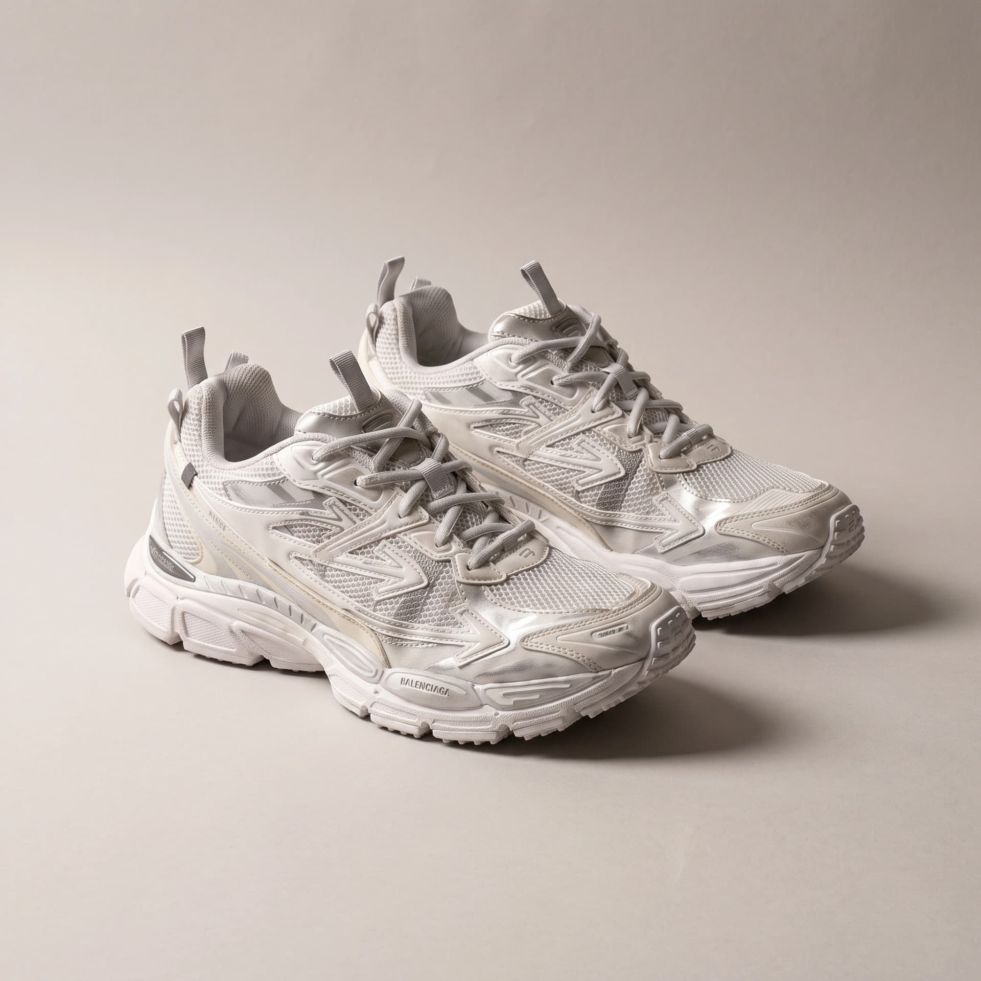 Balenciaga Runner blanche, la paire vue de trois quarts sur fond gris clair.