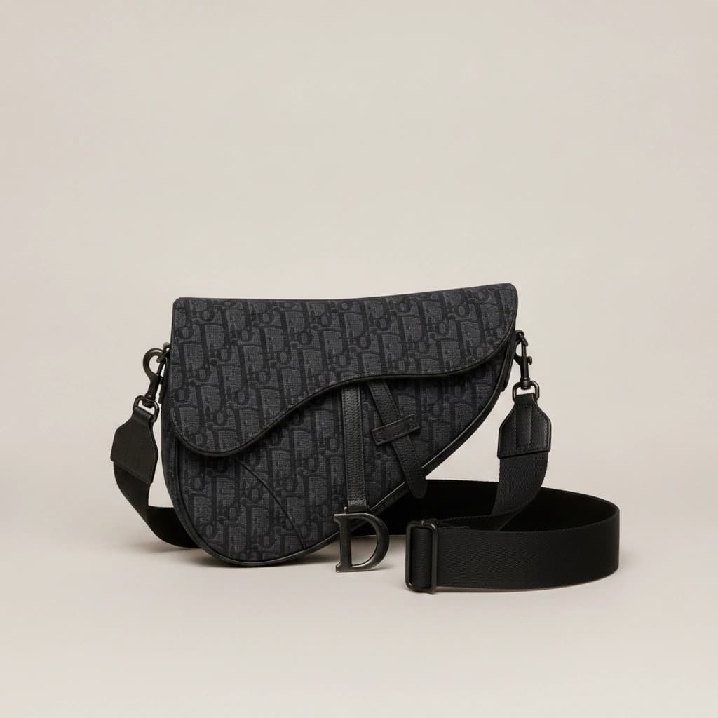 Dior Saddle Bag Oblique noir, de trois quarts sur fond gris clair, bandoulière posée.